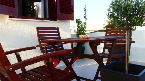 a wooden table and chairs on a patio at Theasis Athens in Athens