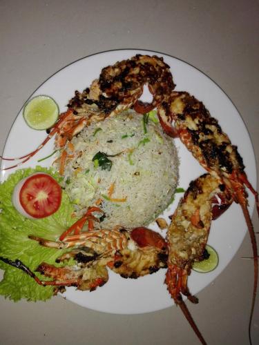 a plate of food with shrimp and rice and a salad at Turtle Paradise in Tangalle