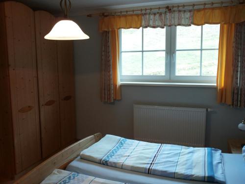 1 dormitorio con cama y ventana en Dirnbergerhof, en Mondsee