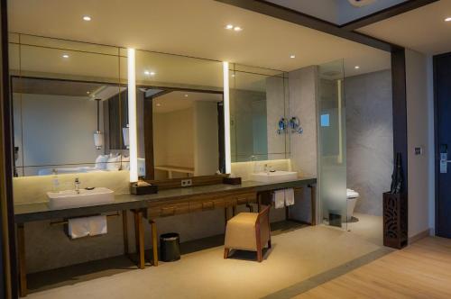 a bathroom with two sinks and a large mirror at Ketapang Indah Hotel in Banyuwangi