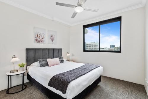 a bedroom with a large bed and a large window at Republic Apartments Brisbane City in Brisbane