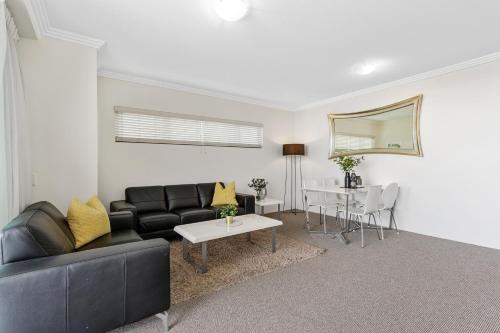 a living room with a couch and a table at Republic Apartments Brisbane City in Brisbane