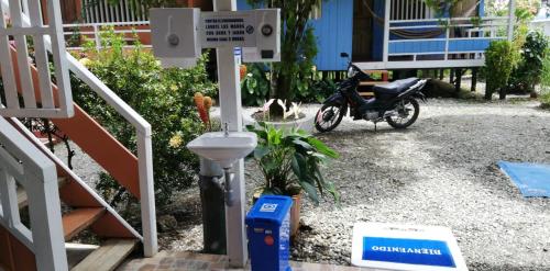 a motorcycle parked in a driveway next to a house at Hotel Palmas del Pacifico in Nuquí