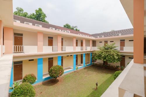 anterior view of a building with a courtyard at RedDoorz Syariah Plus @ Wisma Bougenville Karawaci in Tangerang