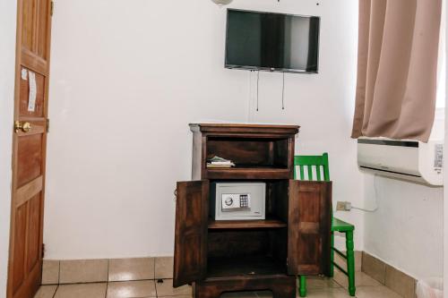 a room with a tv and a cabinet with a microwave at Hotel Casa Amelia in Flores