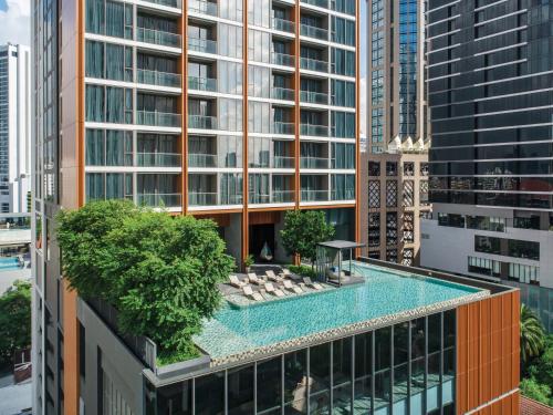a swimming pool on top of a building at Oakwood Suites Bangkok in Bangkok