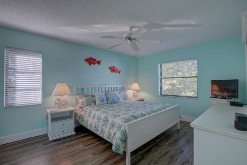 1 dormitorio con 1 cama y ventilador de techo en Anna Maria Island Beach Palms 7A, en Bradenton Beach