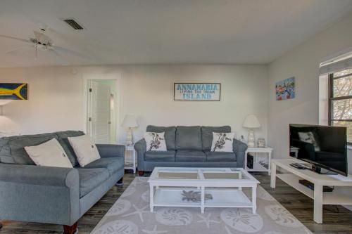 a living room with two blue couches and a tv at Anna Maria Island Beach Palms 7A in Bradenton Beach