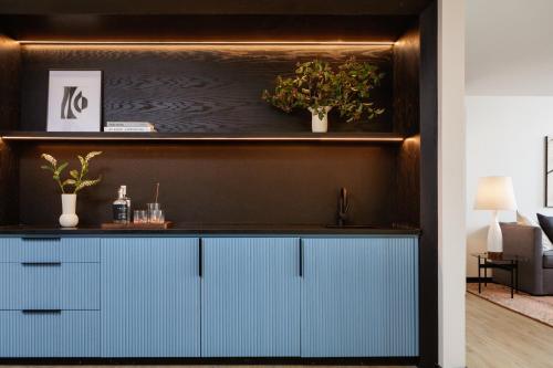 a kitchen with blue cabinets and plants on a wall at Kimpton Hotel Fontenot by IHG in New Orleans
