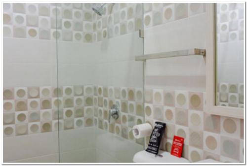um banheiro com chuveiro com porta de vidro em RedDoorz near Jogja City Mall 4 em Yogyakarta
