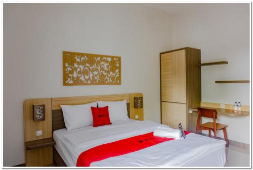 um quarto com uma cama com um cobertor vermelho em RedDoorz near Jogja City Mall 4 em Yogyakarta