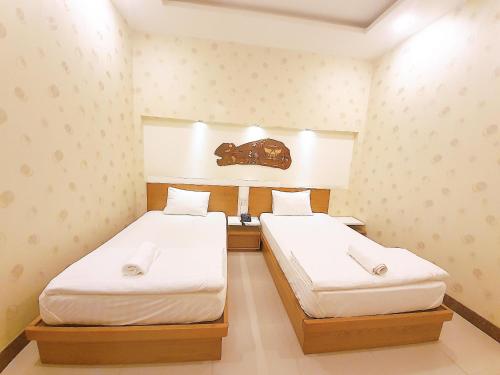 two beds in a small room with white sheets at Mui Tau Hotel Phan Ri Cua in Tuy Phong