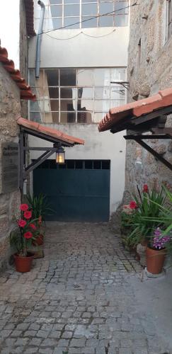 an entrance to a building with a blue door and flowers at Casa Bento Teixeira in Belmonte