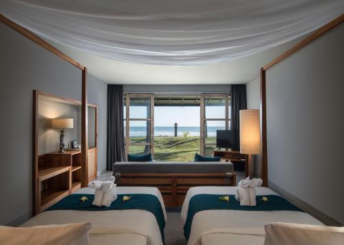 プルカンにあるUmadewi Surf & Retreatのベッド2台が備わる海の景色を望むホテルルームです。