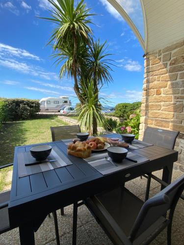 une table avec une assiette de nourriture dessus dans l'établissement Loriot1- Appartement vue mer sur le fort bloqué ploemeur, à Ploemeur