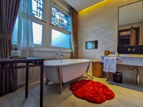 een badkamer met een wit bad en een raam bij Cours Et Pavillons in Beijing
