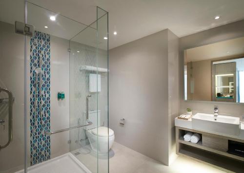 een badkamer met een toilet, een wastafel en een douche bij OZO North Pattaya in Pattaya