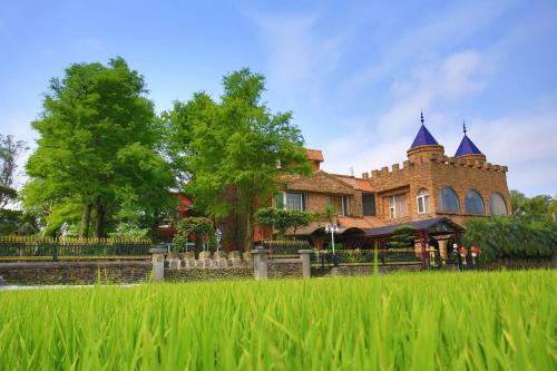 a large house with a grass field in front of it at Xin Yuan My Dream Castle in Dongshan