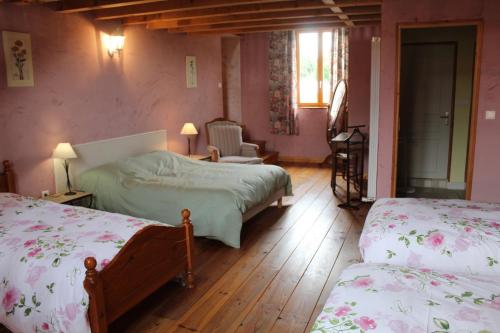 a bedroom with two beds in a room with wooden floors at COMME UN COQ EN PÂTE in Bourg-le-Comte