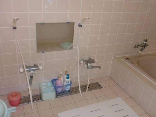 y baño con bañera, lavabo y espejo. en Hoshi Ryokan, en Tsuwano