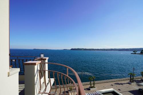 a view of a large body of water from a balcony at Hotel Du Lac Gardone Riviera in Gardone Riviera