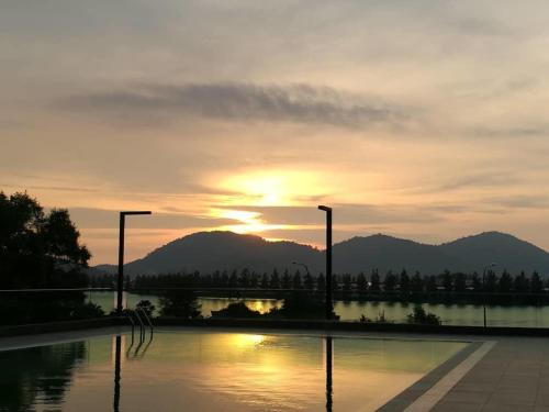 ルムットにあるMarina Heights Seaview Resort Apartment IIの山を背景にした水の上の夕日