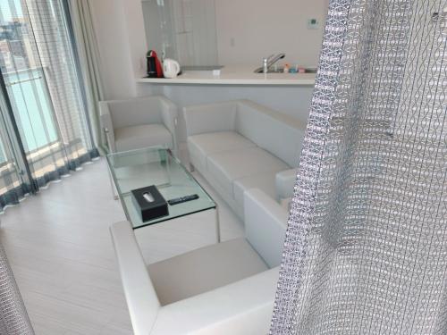 un soggiorno con divano bianco e tavolo in vetro di PG Kuromon ad Osaka