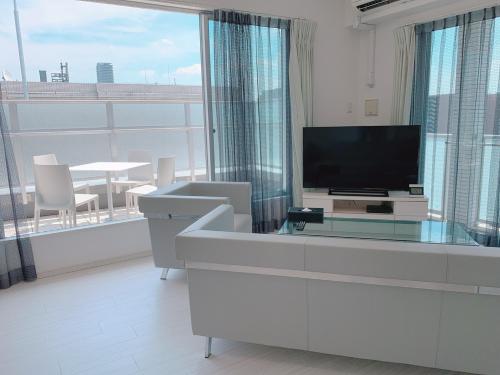 Una sala de estar con televisión y una gran ventana. en PG Kuromon, en Osaka