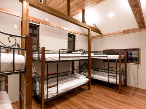 a room with three bunk beds in a house at The Kura in Iiyama