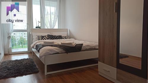 a bedroom with a bed and a window at CITY VIEW Zamenhofa in Świdnica