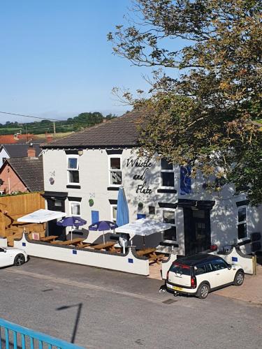 a building with umbrellas and a car parked in front of it at The Whistle and Flute in Barnetby le Wold