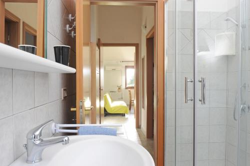 La salle de bains est pourvue d'un lavabo et d'une douche. dans l'établissement Casa nel vigneto con vista mare, à Magomadas
