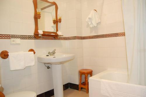 a bathroom with a sink and a toilet and a tub at Hotel Antonio Conil in Conil de la Frontera