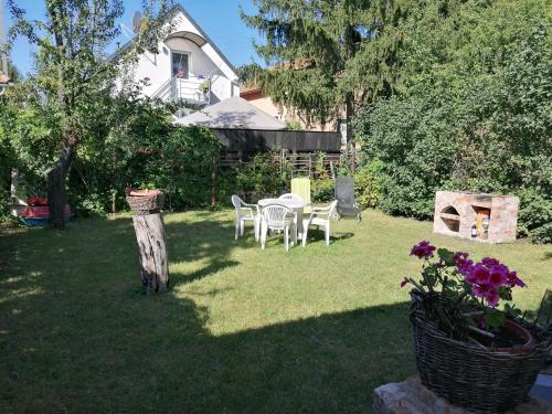 メゼーケヴェシュトにあるMenta Apartmanの芝生の中にテーブルと椅子が置かれた庭園