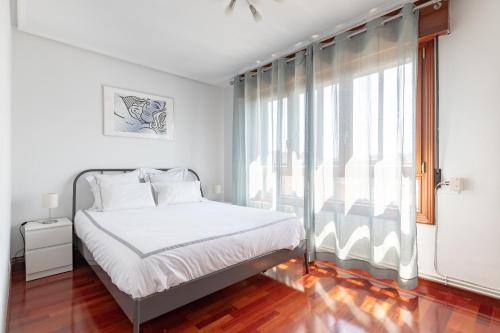 um quarto com uma cama e uma grande janela em Precioso apartamento cerca de Bilbao Exhibition Center -BEC-, Bilbao y playas em Barakaldo