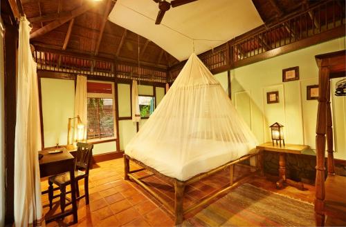 a bedroom with a bed with a net on it at Bhakti Kutir in Palolem
