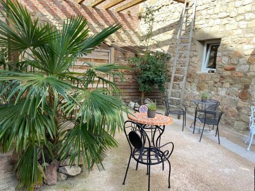 a patio with a table and chairs and palm trees at Toscanahaus in Bad Sobernheim