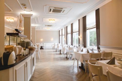 a restaurant with white tables and chairs and windows at ConventGarten Hotel & Restaurant - am Nord-Ostsee-Kanal in Rendsburg