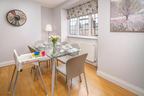 a dining room with a glass table and chairs at Castle Properties:Eton-The College in Windsor
