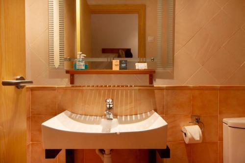 y baño con lavabo, espejo y aseo. en Estudio en la Molina (bus a pistas) WIFI, en Alp