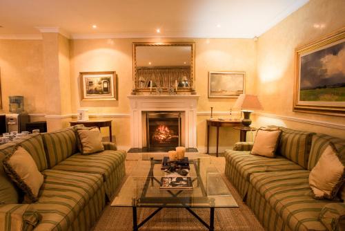 a living room with two couches and a fireplace at Leighwood Lodge in Johannesburg