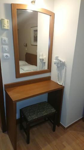 a bathroom with a wooden vanity with a mirror at Economy Hotel in Athens