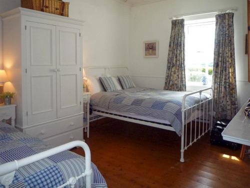 基洛格林的住宿－Fleur Cottage Killorglin by Trident Holiday Homes，一间卧室设有两张床和窗户。