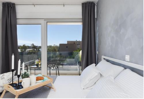 a bedroom with a white bed and a large window at Villa Maris Nin in Nin