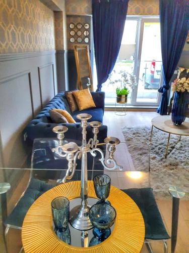 a living room with a glass table and a couch at Portobella Airport Aparthotel - Self Check in in Otopeni
