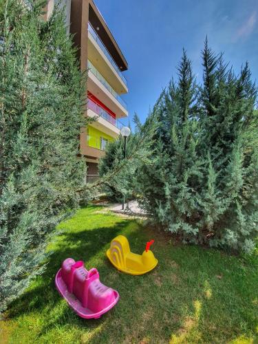 two rubber shoes in the grass near some trees at Portobella Airport Aparthotel - Self Check in in Otopeni