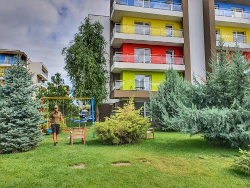 a person walking in a yard in front of a building at Portobella Airport Aparthotel - Self Check in in Otopeni