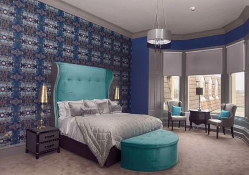 a bedroom with a bed and a blue wall at Richmond Park Hotel in Boʼness