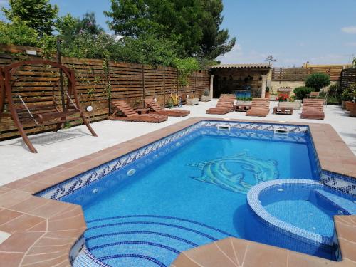 uma piscina num pátio com cadeiras e um banco em Cal Roig Hotel Rural em Vilafranca del Penedès