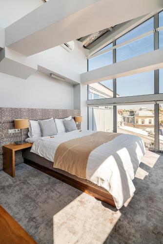 a bedroom with a large bed and a large window at Aparthotel Best Views in Krakow